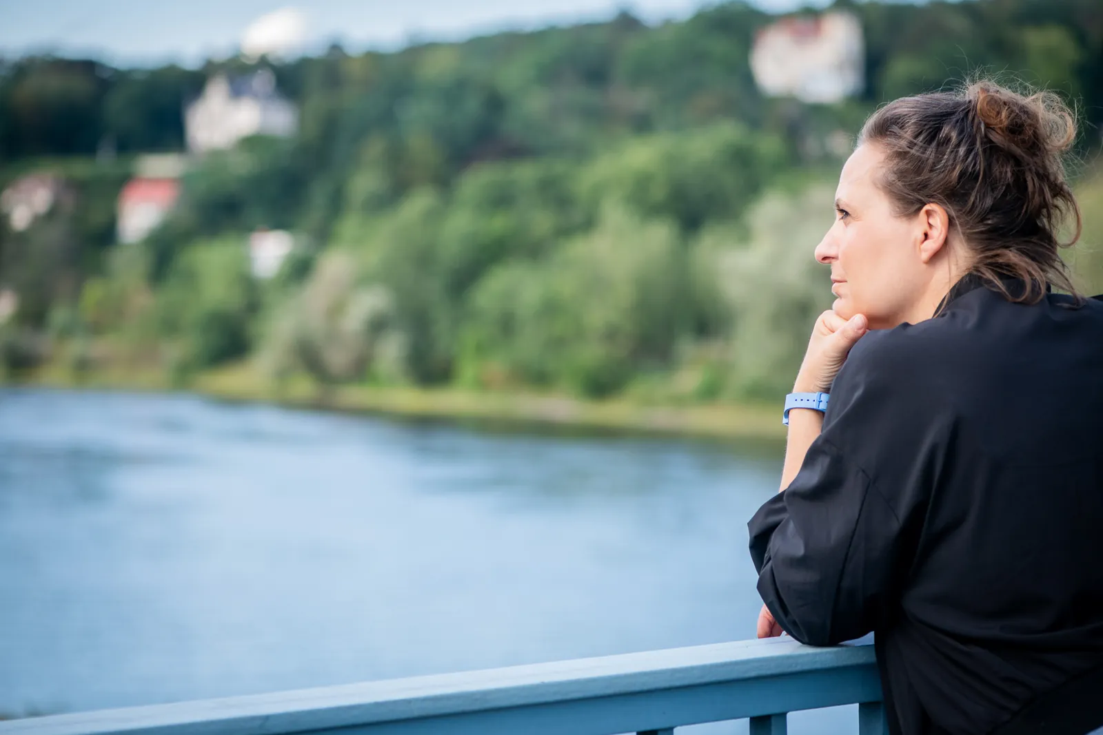 Freie Trauerrednerin Annette Krönert blickt nachdenklich über einen Fluss ins Grüne