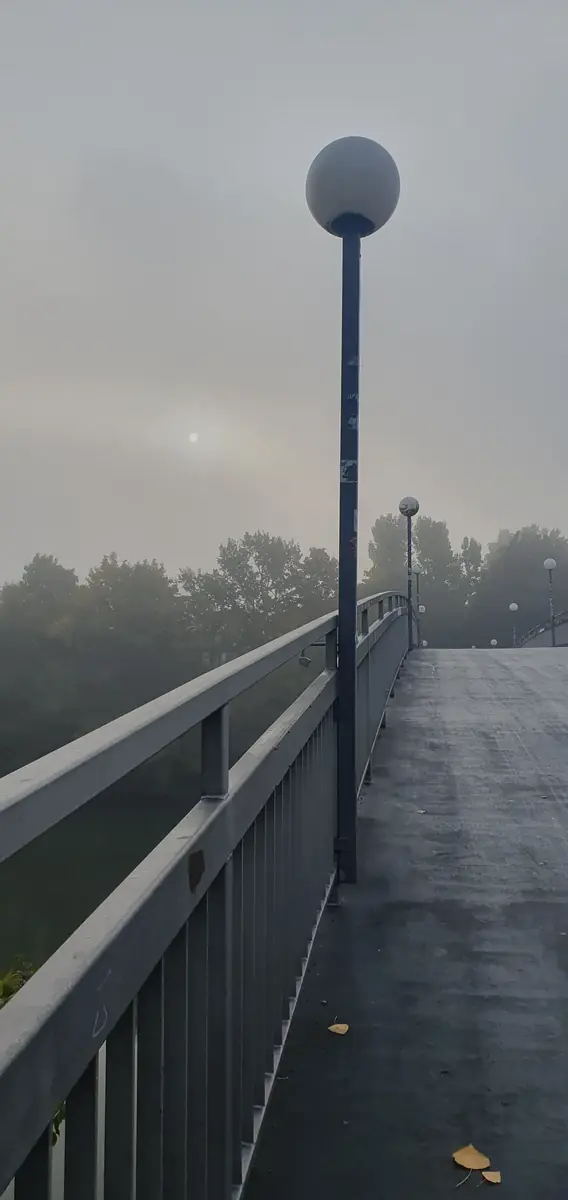 Laterne im Nebel an einem Geländer