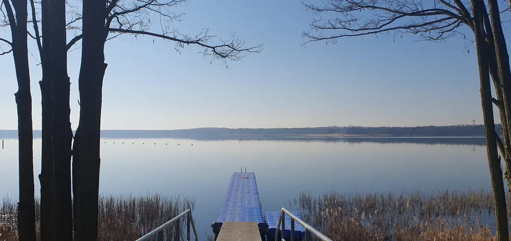 Steg in einen ruhigen See bei Morgenlicht